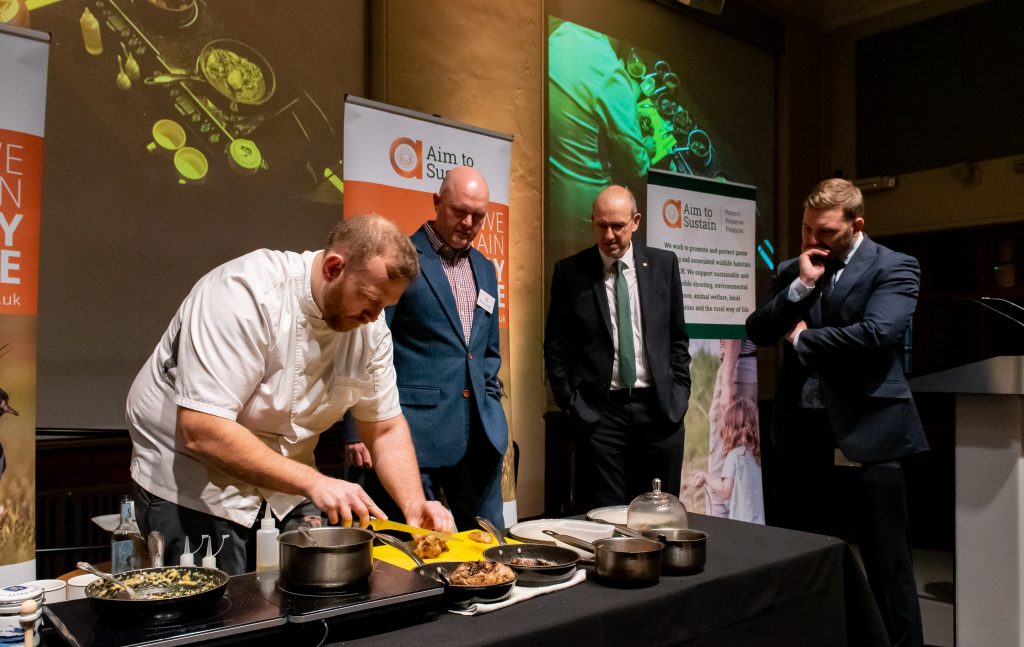 Hywel Griffith cooks with game at Aim to sustain Senedd event